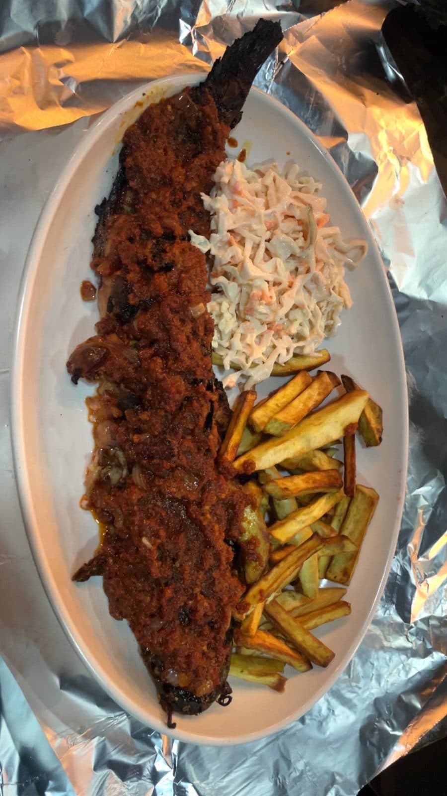 Grilled catfish in pepper sauce with chips and coleslaw