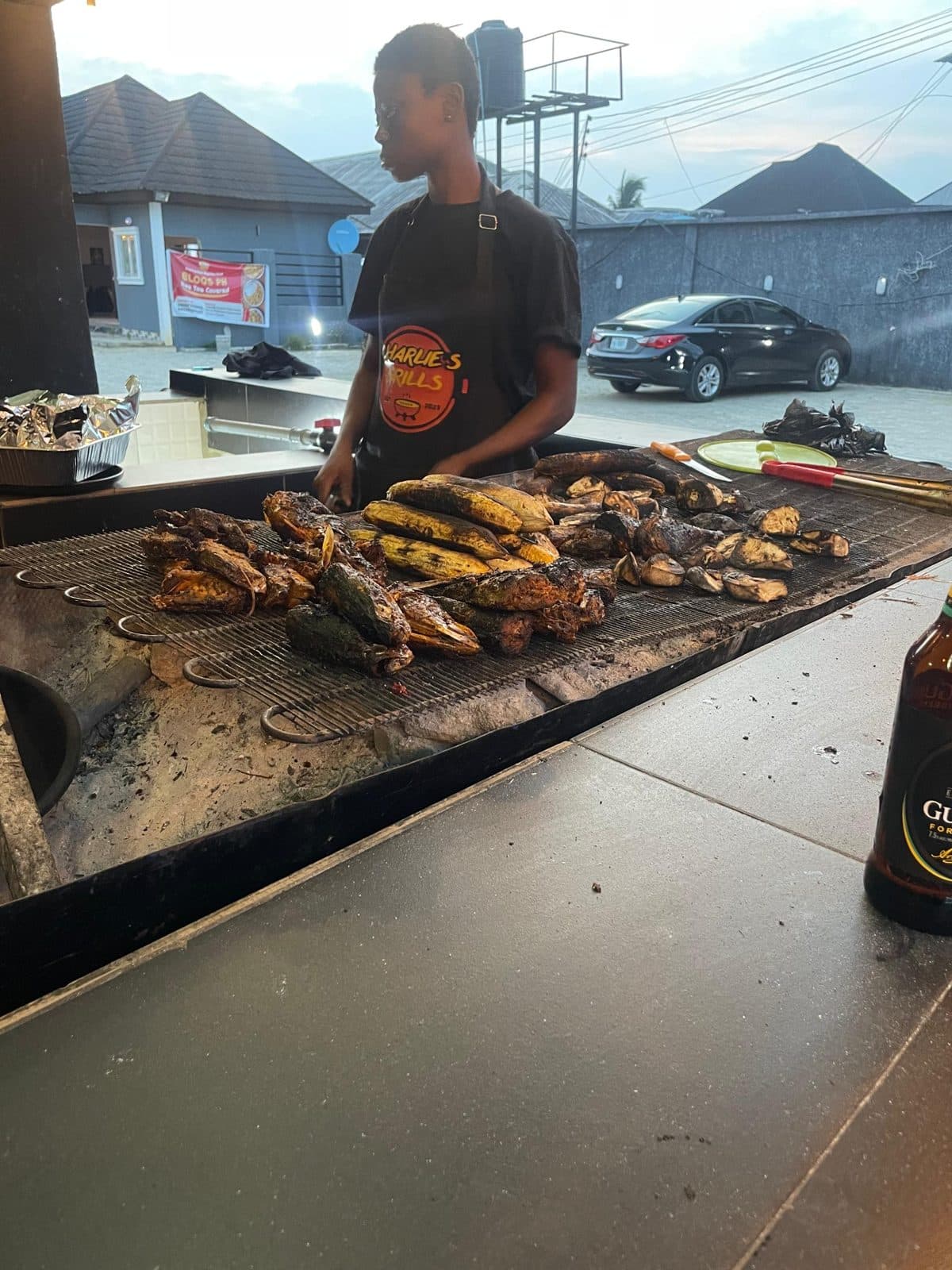 Charlie's Grill cook working the open charcoal grill