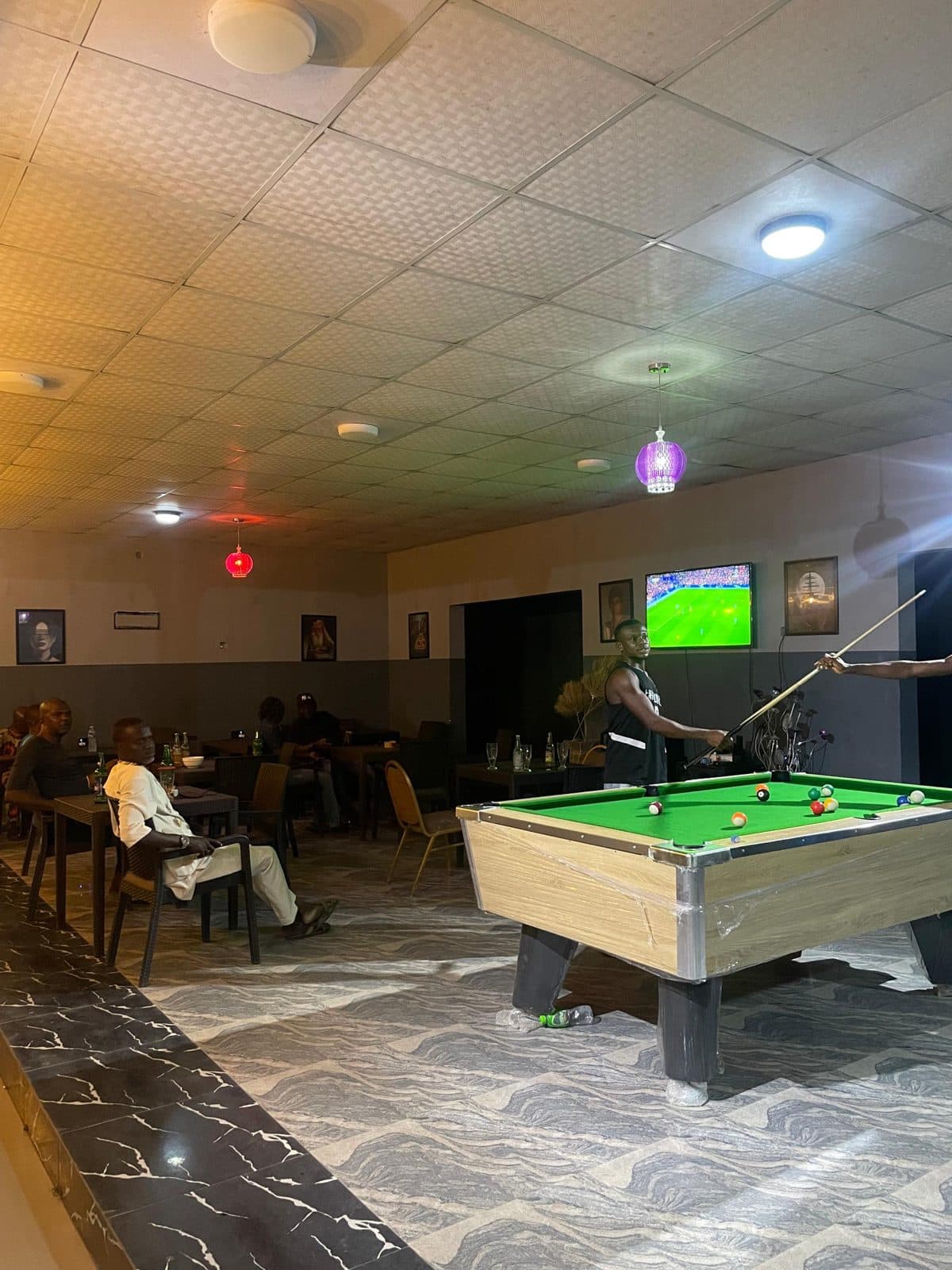 Pool game with football showing on the wall screen