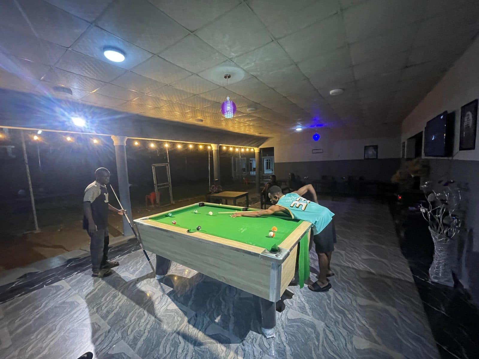 Guests playing pool in the lounge at night